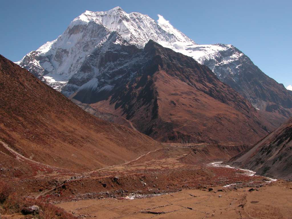 Manaslu 08 06 Samdo Benath Pang Puche I looked back to see Samdo beneath snow-topped Pang Puche (6335m). The simple houses of Samdo (3860m) stand at the junction of three valleys, with a major Tibetan trade route heading east through the village and over the Lajyang La (5098m) to Rhee village in Tibet, a day�s walk from here.
